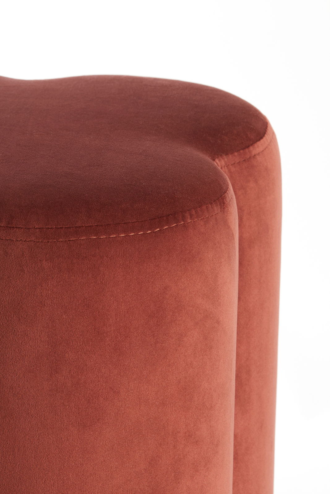 Nahaufnahme eines roten Sitzpuffs mit weicher, samtiger Oberfläche, seitliche Perspektive