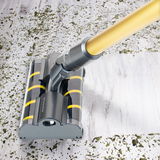 Staubsaugerbürste mit gelbem Griff auf hellem Holzboden, umgeben von Schmutz, aus der Vogelperspektive