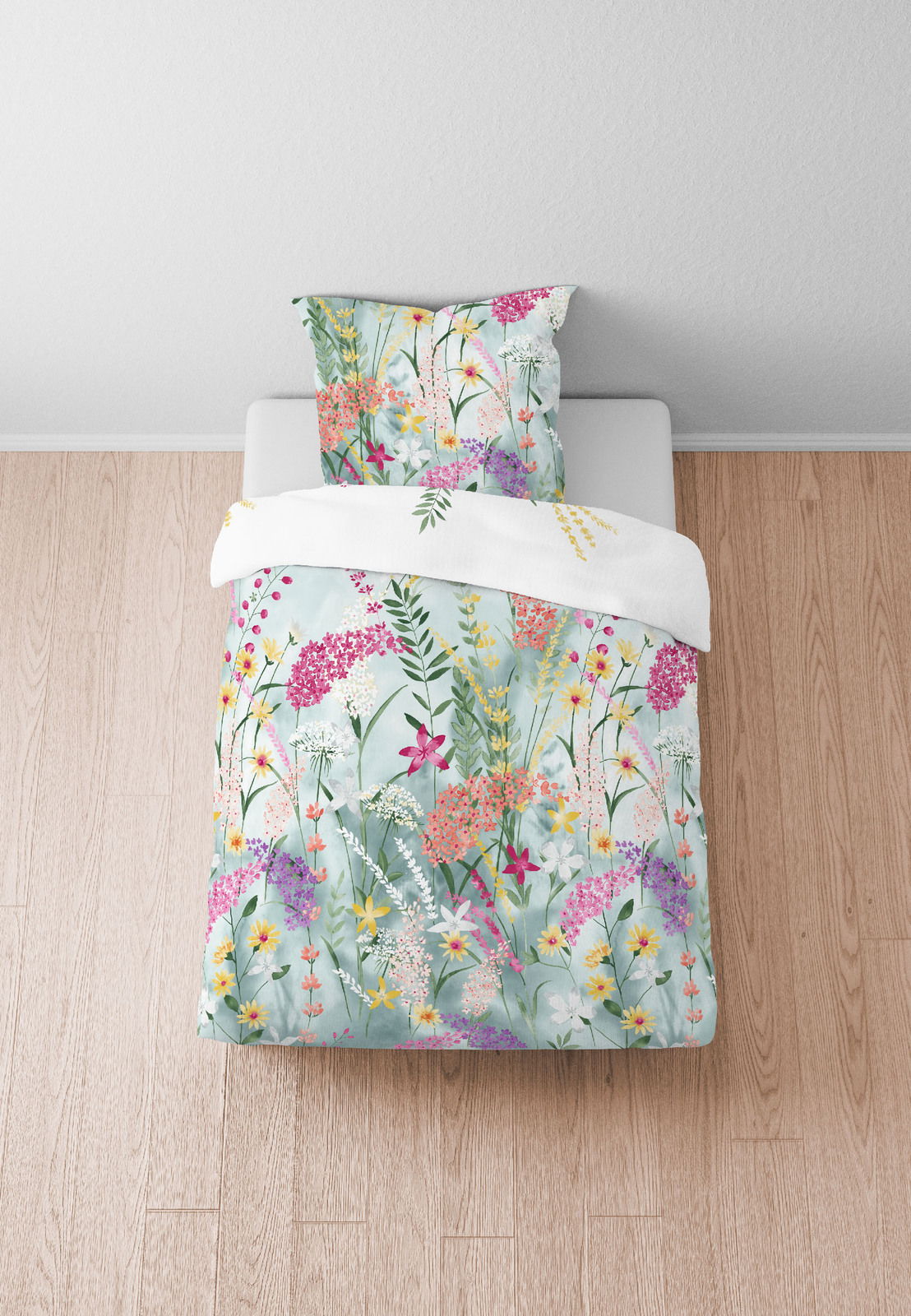 Bettwäsche-Set mit floralem Muster in Pastellfarben, aus der Vogelperspektive fotografiert.