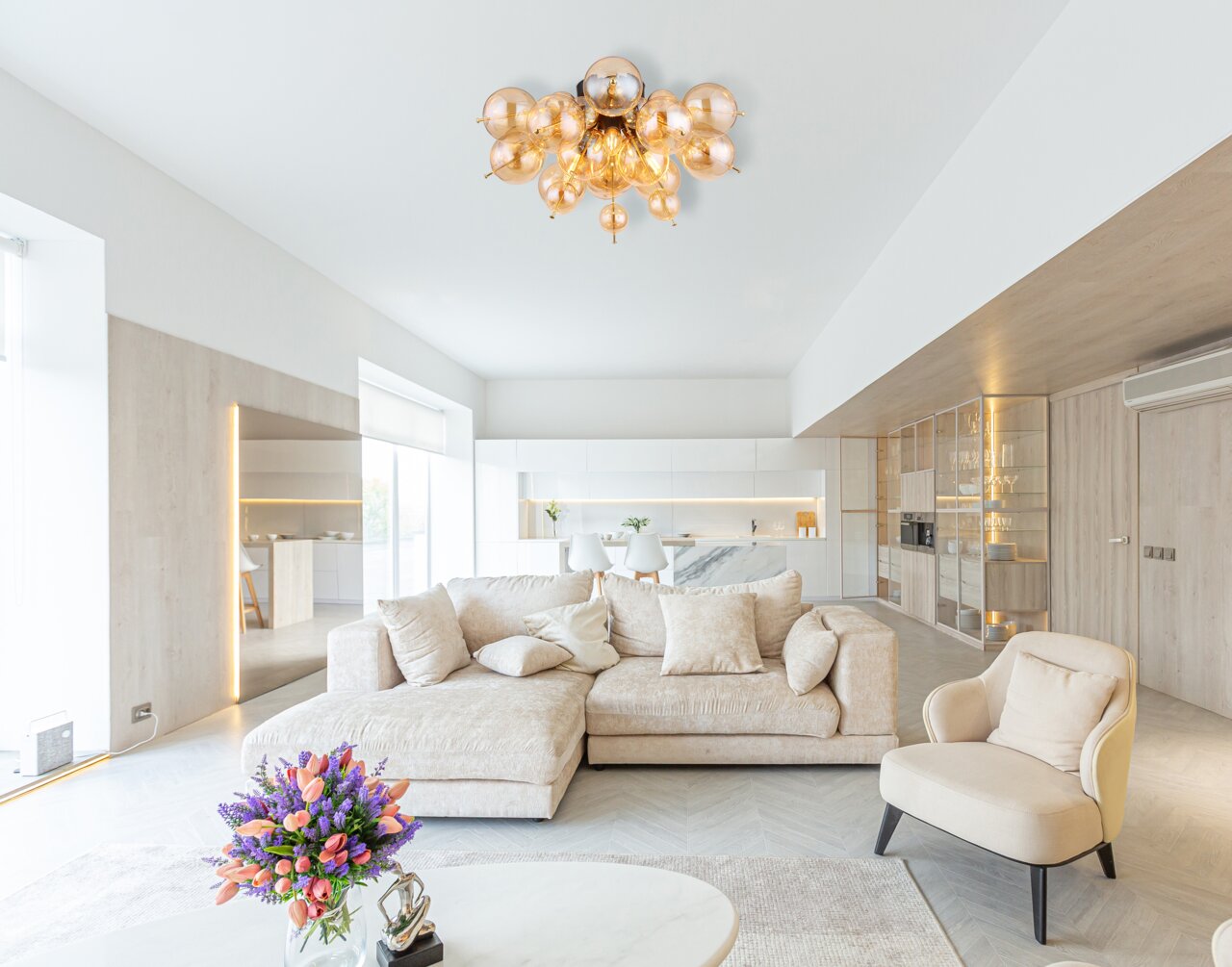 Moderne Deckenleuchte mit mehreren kugelförmigen Glaselementen in einem stilvollen Wohnzimmer, Perspektive von unten.