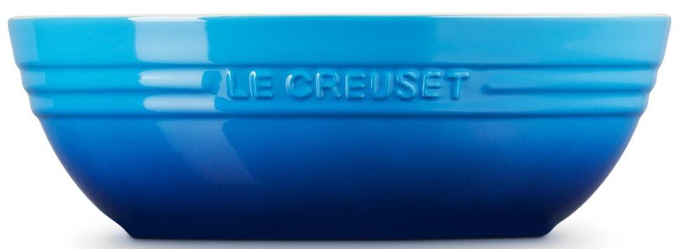 Blaue Le Creuset Keramikschüssel mit eingeprägtem Logo, seitliche Ansicht vor weißem Hintergrund