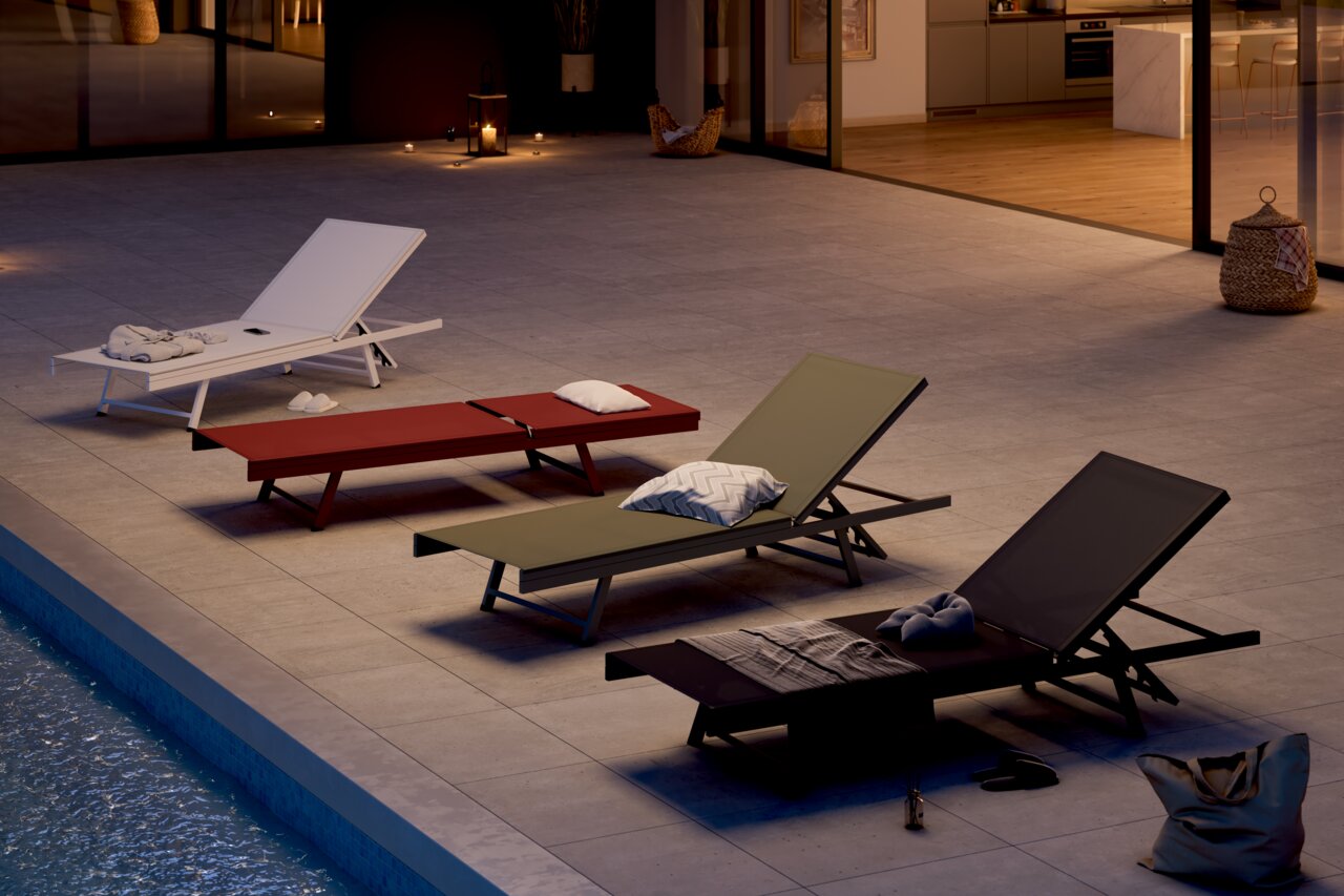 Vier Sonnenliegen in verschiedenen Farben auf einer Terrasse am Pool, bei Abenddämmerung von schräg oben betrachtet.