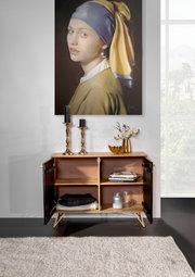 Kommode mit geöffneten Türen, dekoriert mit Kerzenhaltern und einer Vase, vor einem Gemälde, aus der Frontalperspektive fotografiert.