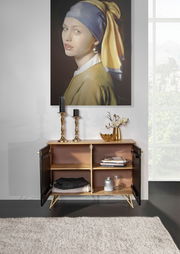 Kommode mit geöffneten Türen, dekoriert mit Kerzenhaltern und einer Vase, vor einem Gemälde, aus der Frontalperspektive fotografiert.