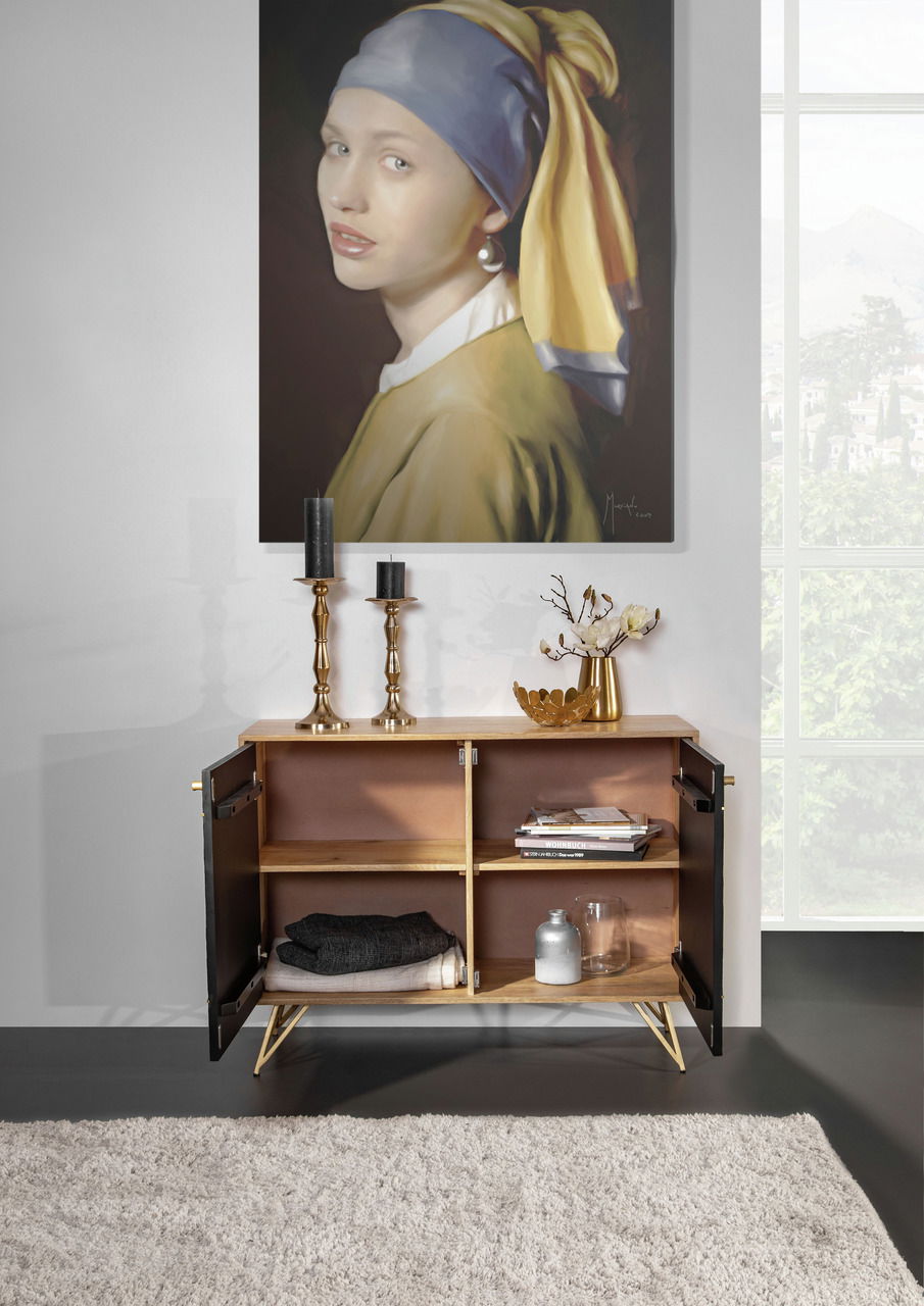 Kommode mit geöffneten Türen, dekoriert mit Kerzenhaltern und einer Vase, vor einem Gemälde, aus der Frontalperspektive fotografiert.