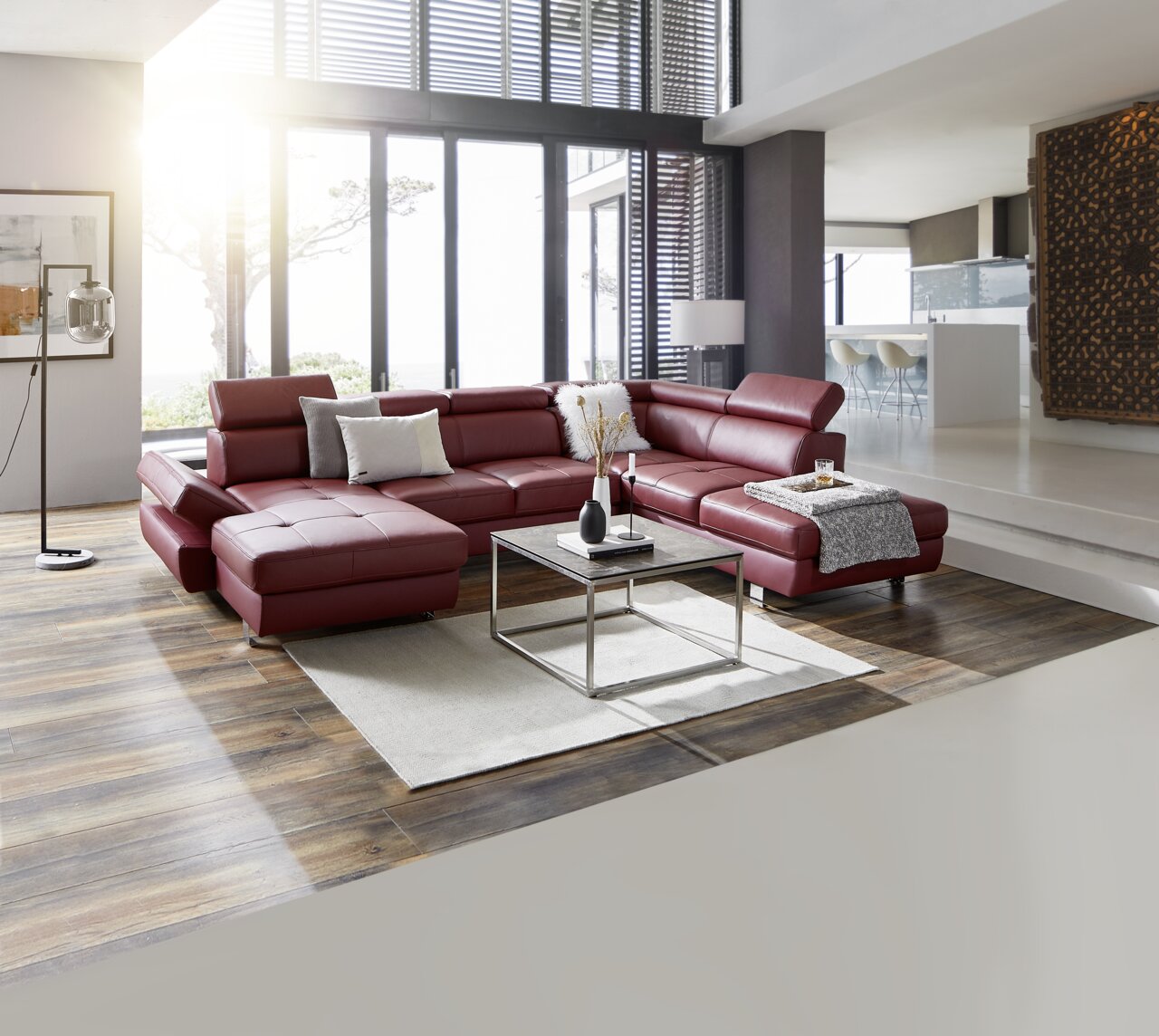 Stylife Wohnlandschaft TORINO Moderne Polsterrundecke in einem eleganten Wohnzimmer, aus rotem Leder mit verstellbaren Kopfstützen, von vorne betrachtet.
