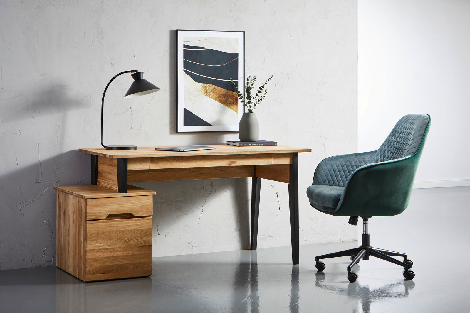 Moderner Schreibtisch aus Holz mit schwarzem Metallgestell, seitlich mit Schubladenblock, abgebildet in einem stilvollen Büro mit grünem Drehstuhl und Wanddekoration. Perspektive von vorne.