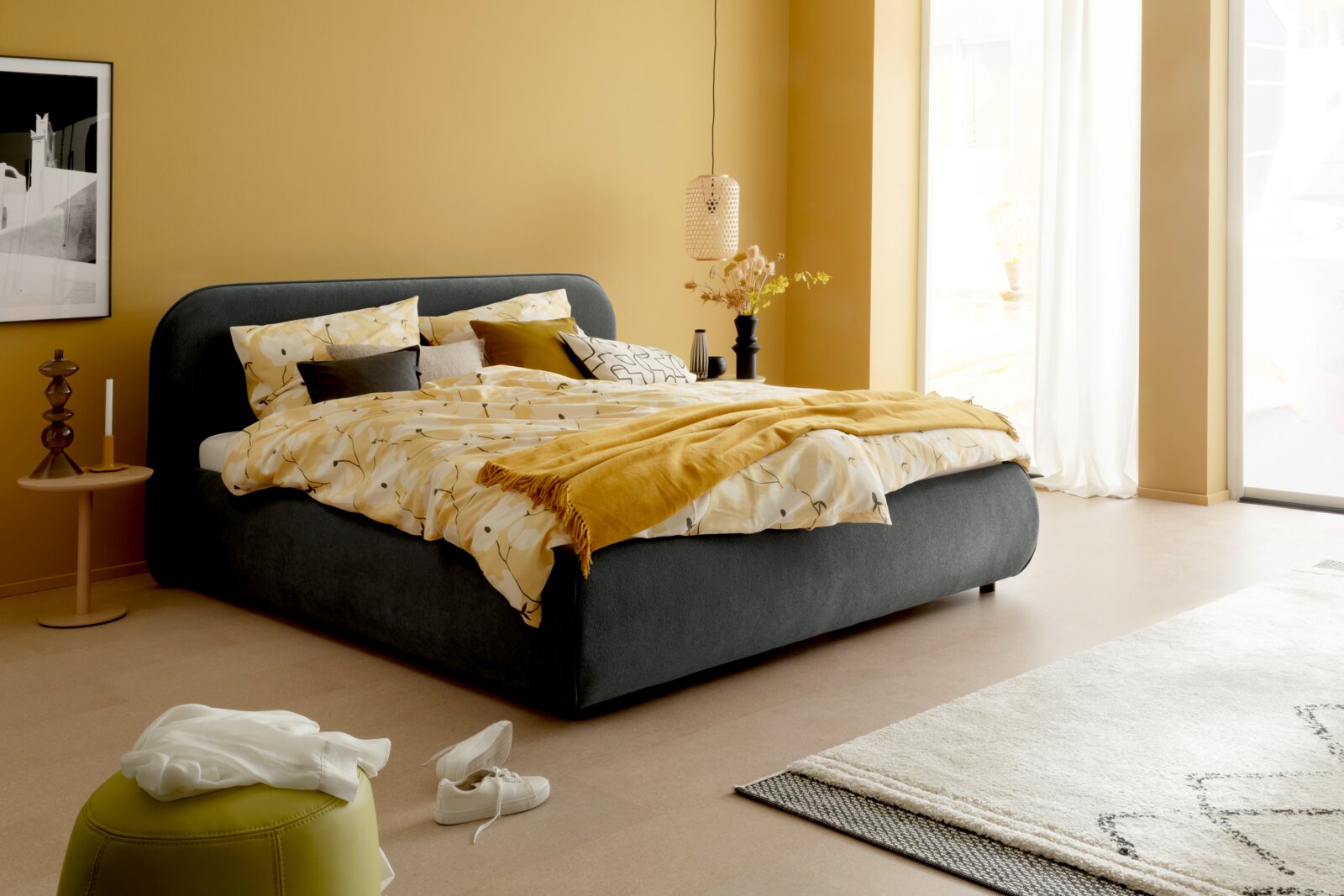 Modernes Polsterbettgestell in einem gemütlichen Schlafzimmer, seitliche Perspektive
