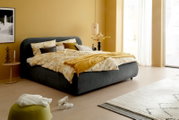 Modernes Polsterbettgestell in einem gemütlichen Schlafzimmer, seitliche Perspektive