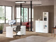 Moderner Büroraum mit weißem Schreibtisch, Bürostuhl und niedrigem Aktenschrank, seitliche Perspektive