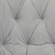 Nahaufnahme eines grauen, gesteppten Stoffbezugs mit Rillenstruktur, perspektivisch von oben betrachtet.