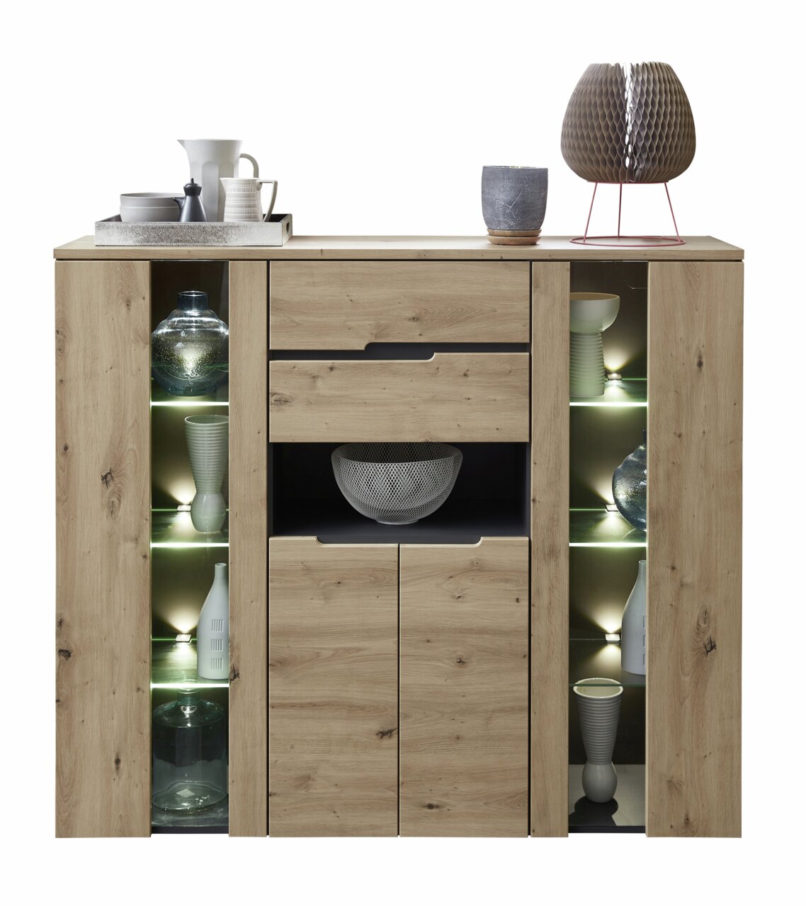 Vooraanzicht van een modern houten hoogkastje met open planken, versierd met serviesgoed en een lamp.