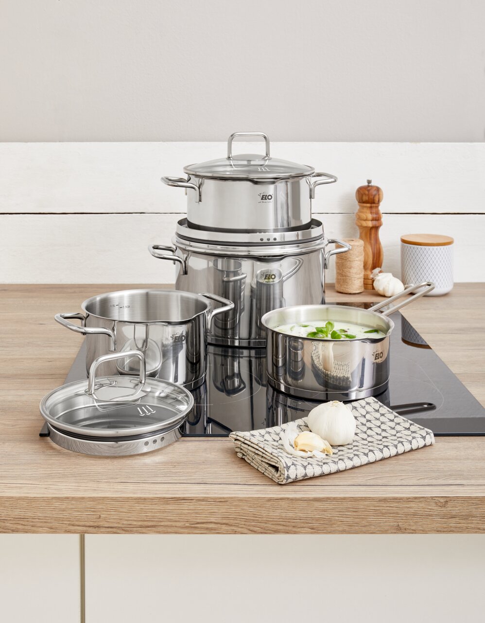 Topfset Smart Steam 4-tlg. aus Edelstahl auf einem Herd, mit einem modernen und eleganten Design, aus der Perspektive von vorne fotografiert.