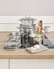 Topfset Smart Steam 4-tlg. aus Edelstahl auf einem Herd, mit einem modernen und eleganten Design, aus der Perspektive von vorne fotografiert.