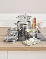 Topfset Smart Steam 4-tlg. aus Edelstahl auf einem Herd, mit einem modernen und eleganten Design, aus der Perspektive von vorne fotografiert.