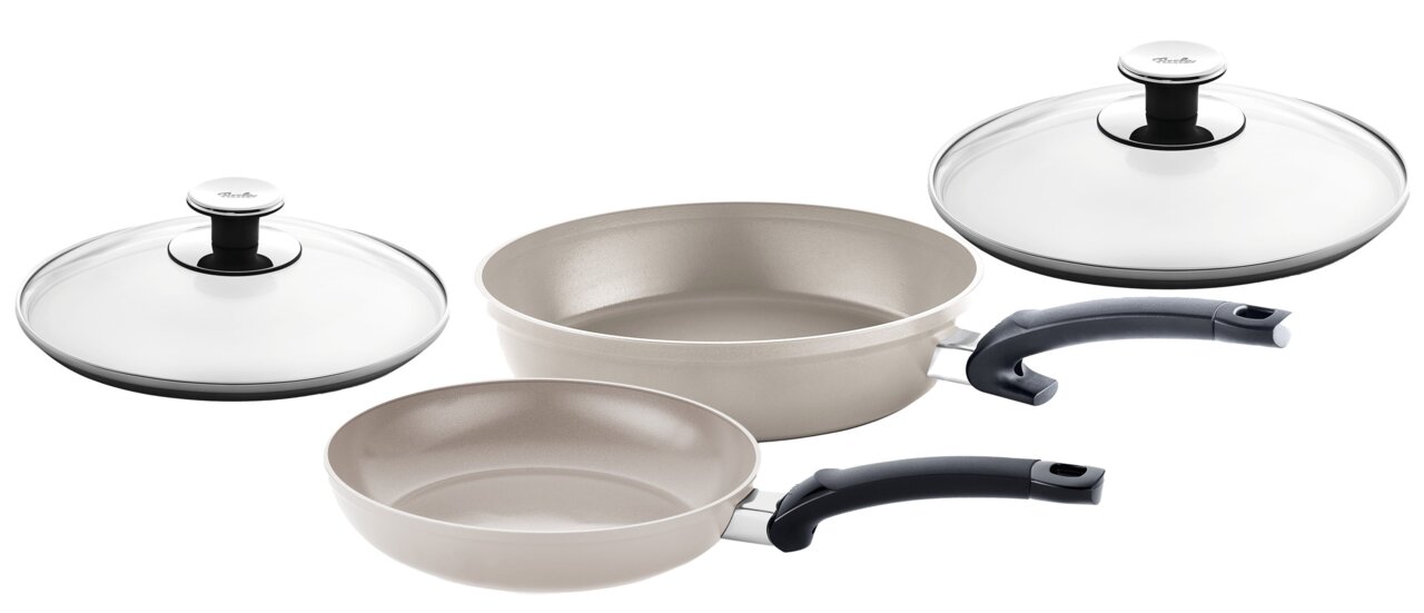 Fissler Pfannenset 2-tlg. CERATAL CLASSIC Zwei Pfannen mit Glasdeckeln, eine in heller Farbe und eine in dunkler Farbe, aus seitlicher Perspektive fotografiert.