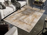 Designer Teppich in einem modernen Wohnzimmer, aus der Vogelperspektive fotografiert, mit einem weißen Sofa und einem Couchtisch auf dunklem Fliesenboden.