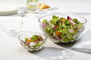 Zwei Glasschalen der Serie Cucina Optic, gefüllt mit frischem Salat, auf einem Tisch von oben betrachtet.