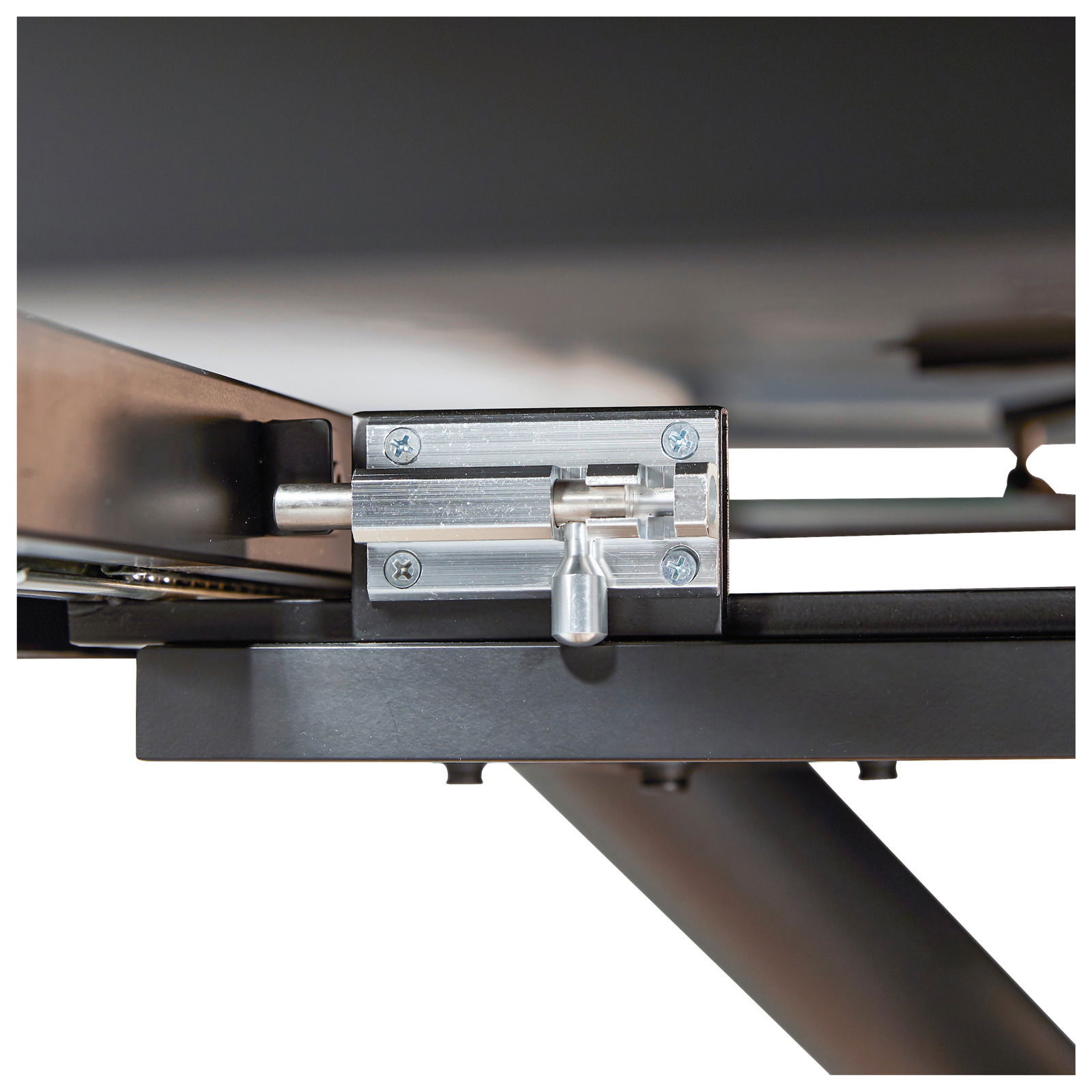 Nahaufnahme eines Metallmechanismus unter einem Tisch, seitliche Perspektive