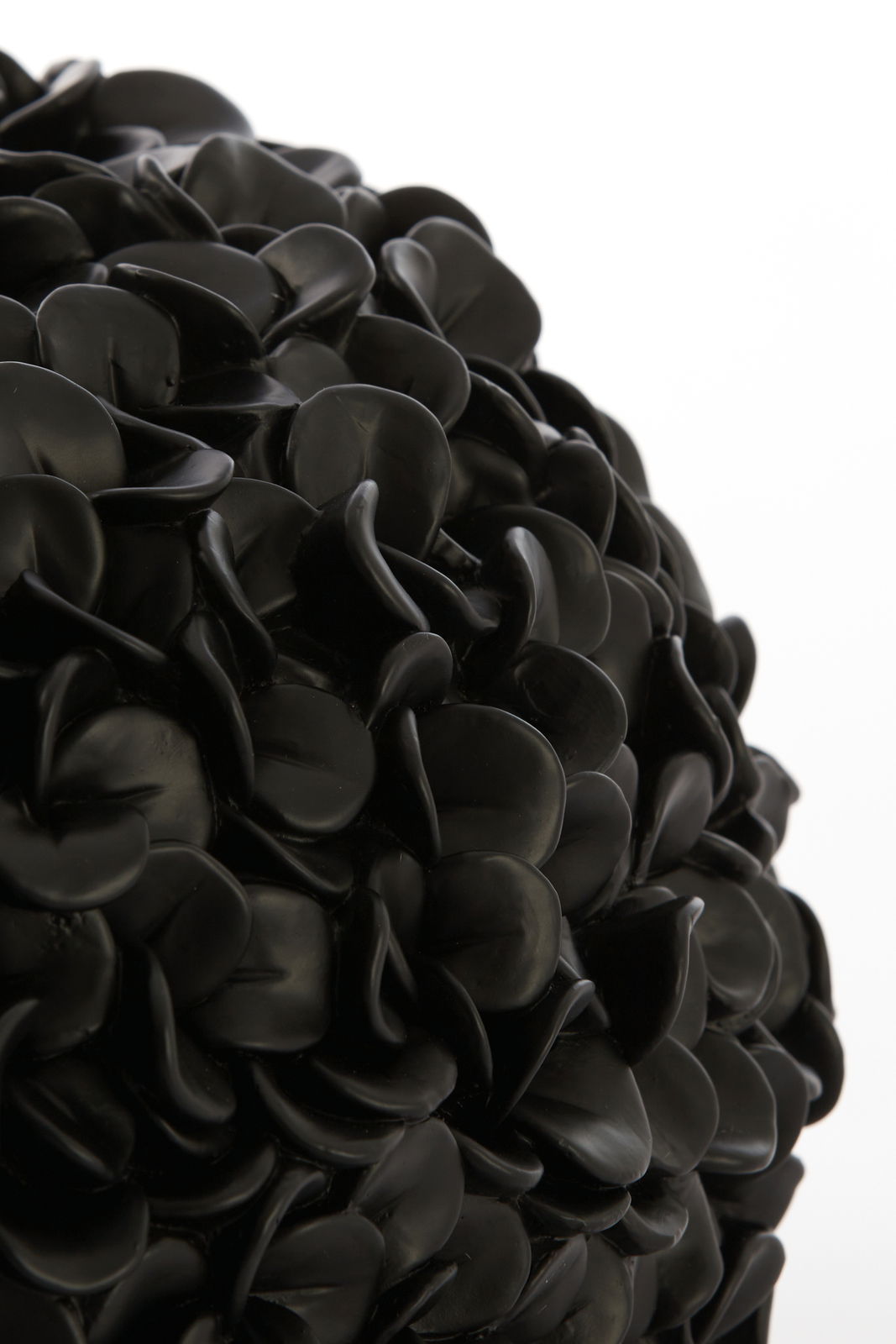 Nahaufnahme einer schwarzen Vase mit mattem Finish und blattähnlicher Struktur.