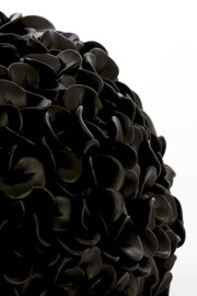 Nahaufnahme einer schwarzen Vase mit mattem Finish und blattähnlicher Struktur.