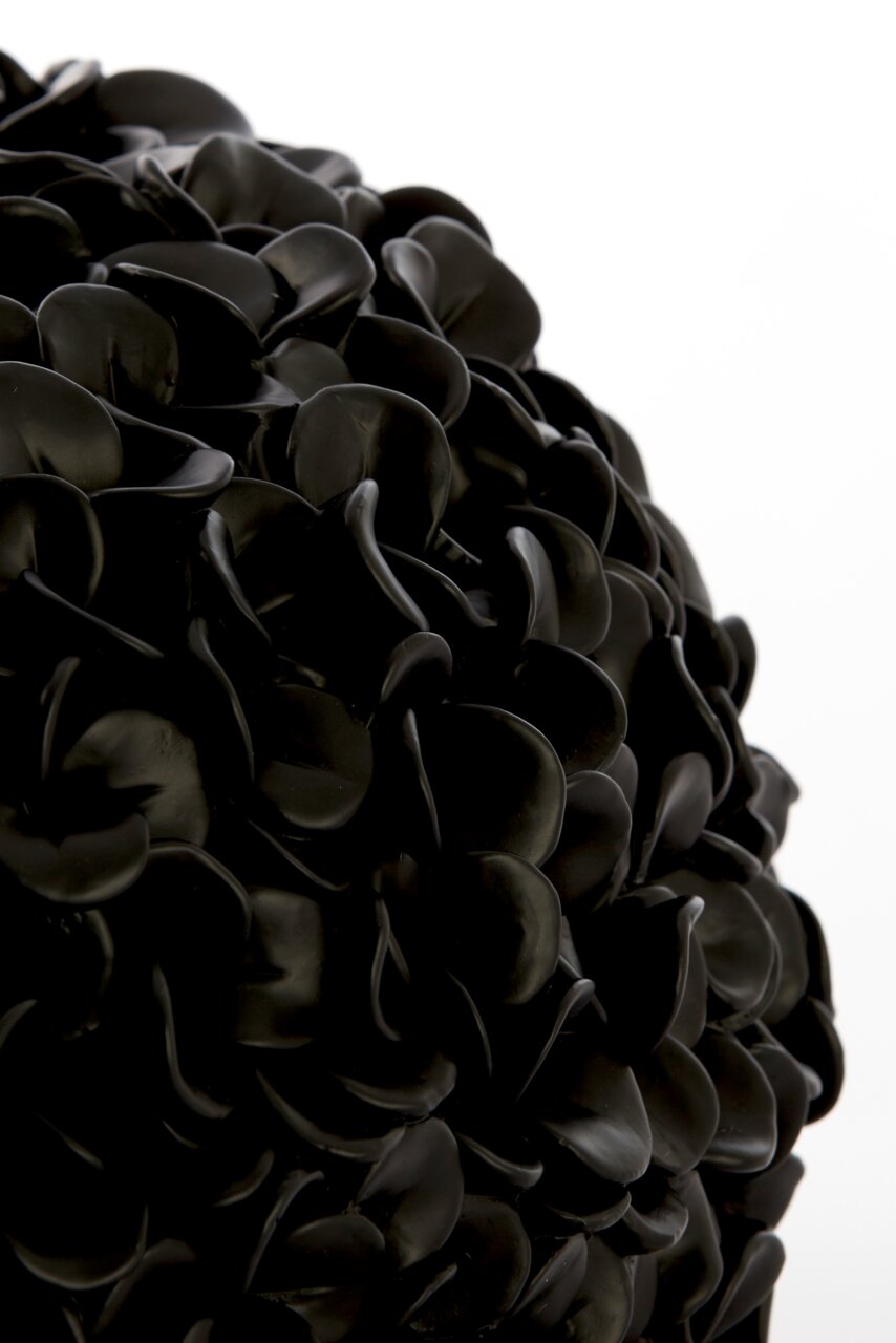Nahaufnahme einer schwarzen Vase mit mattem Finish und blattähnlicher Struktur.