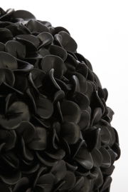 Nahaufnahme einer schwarzen Vase mit mattem Finish und blattähnlicher Struktur.