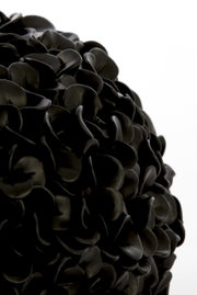 Nahaufnahme einer schwarzen Vase mit mattem Finish und blattähnlicher Struktur.