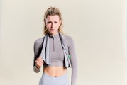 Vrouw met een sporthanddoek om haar nek, van voren gefotografeerd