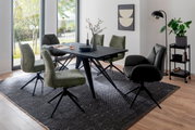 Esszimmer mit modernem Tisch und Stühlen in einem hellen Raum mit großen Fenstern, seitliche Perspektive.