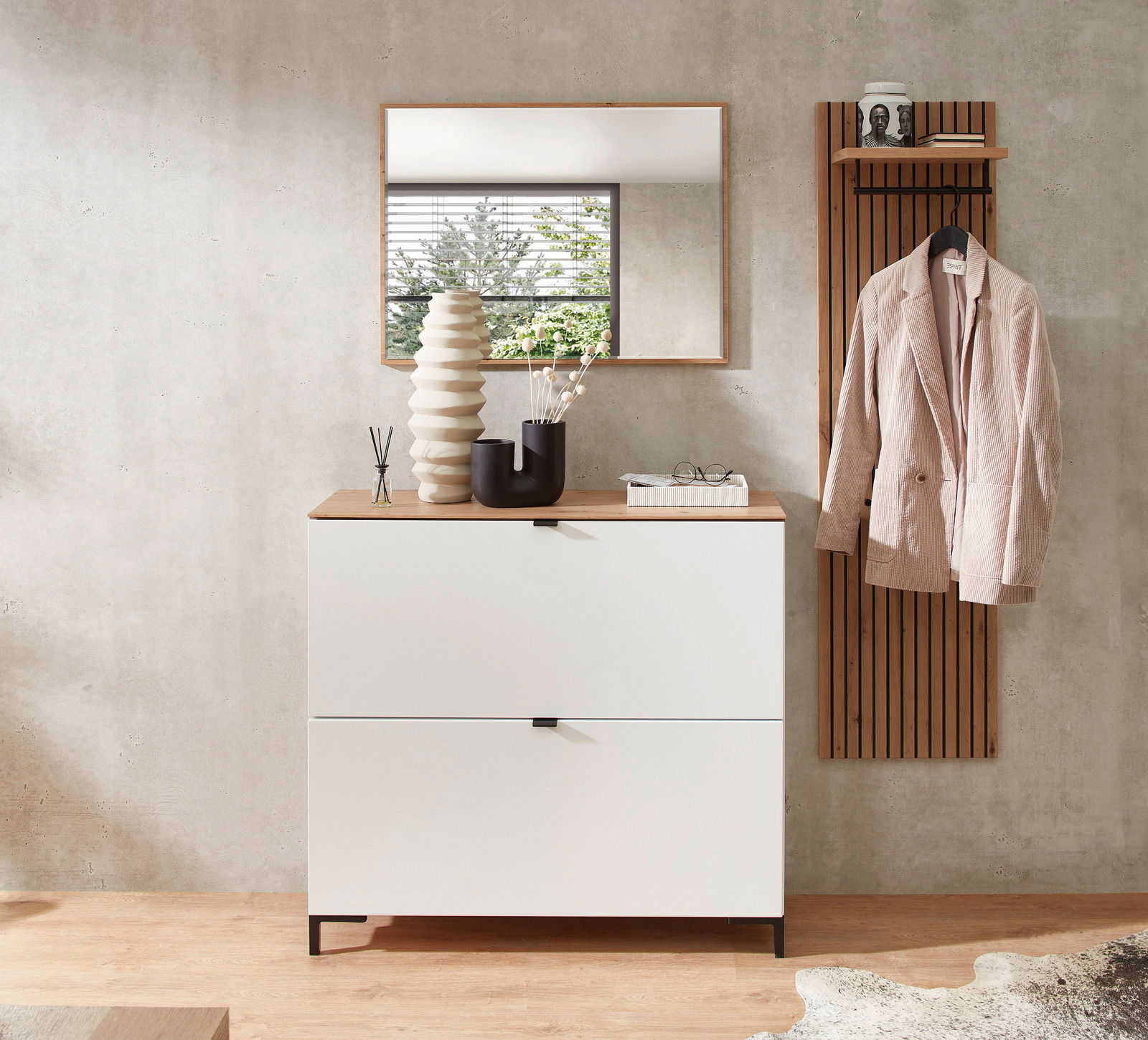 Moderner Eingangsbereich mit weißem Hänge-Schuhschrank und Garderobenpaneel in Holzoptik, frontal fotografiert.