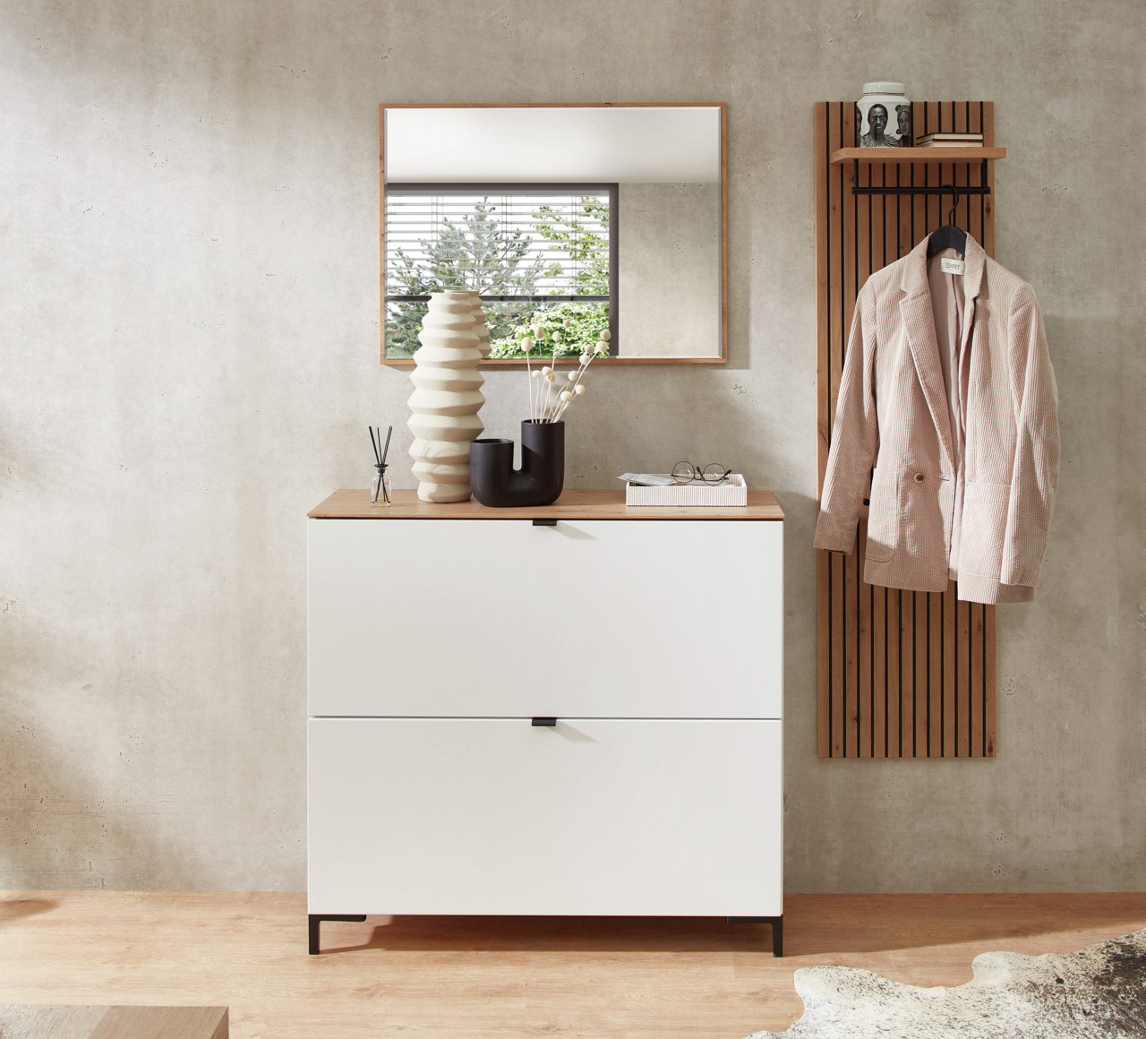 Moderner Eingangsbereich mit weißem Hänge-Schuhschrank und Garderobenpaneel in Holzoptik, frontal fotografiert.