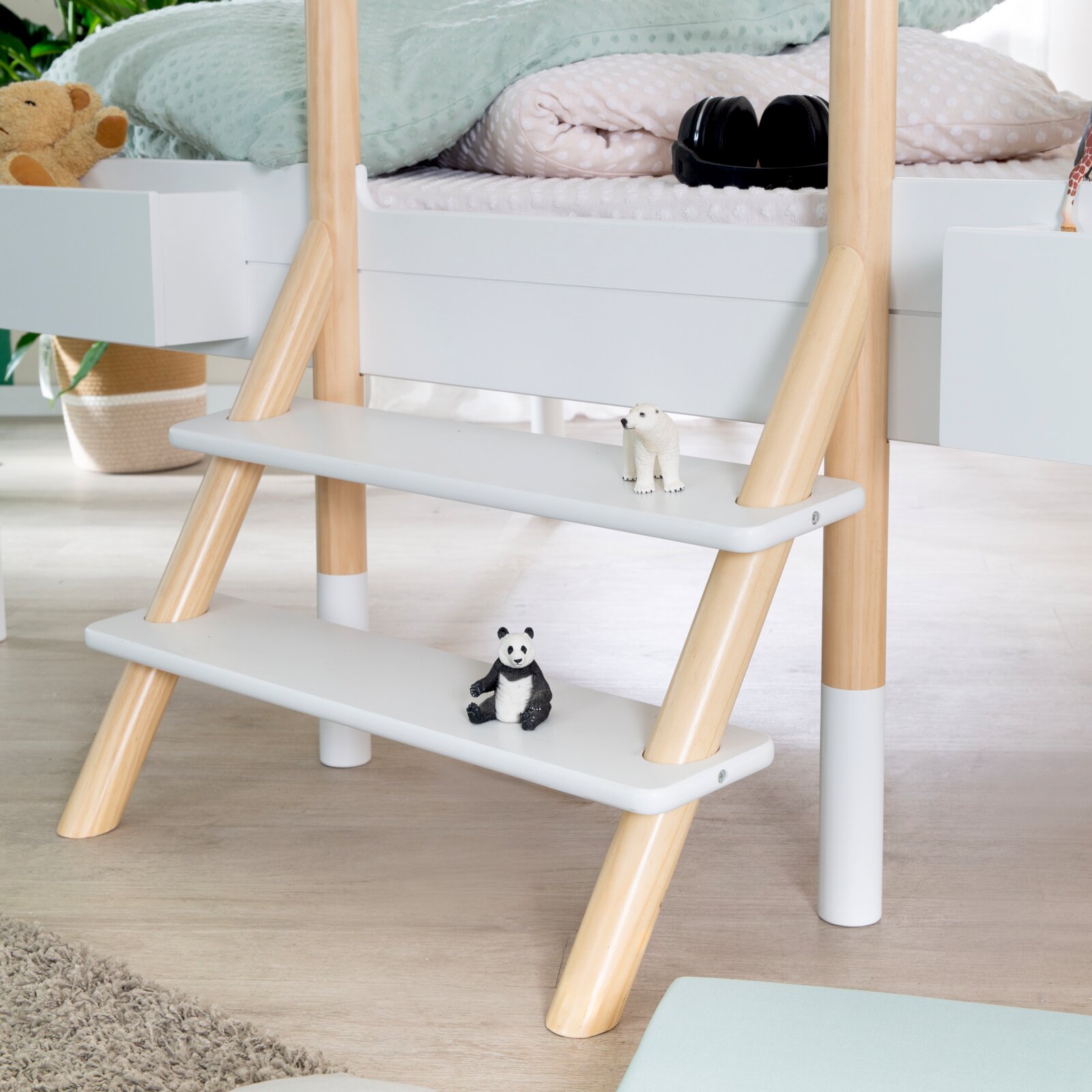 Kinder-Hochbett mit weiß-grauer Leiter und naturfarbenen Holzholmen, aus frontaler Nahansicht leicht von oben gezeigt
