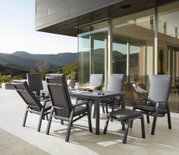 Moderne Gartenmöbel-Sitzgruppe mit Hochlehner-Stühlen und Tisch auf einer Terrasse mit Bergblick, seitliche Perspektive
