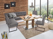 Moderne Eckbank in grauem Leder mit passendem Esstisch und Stühlen, in einem hellen Raum mit großen Fenstern und Holzwand, aus der Vogelperspektive.