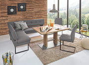 Moderne Eckbank in grauem Leder mit passendem Esstisch und Stühlen, in einem hellen Raum mit großen Fenstern und Holzwand, aus der Vogelperspektive.