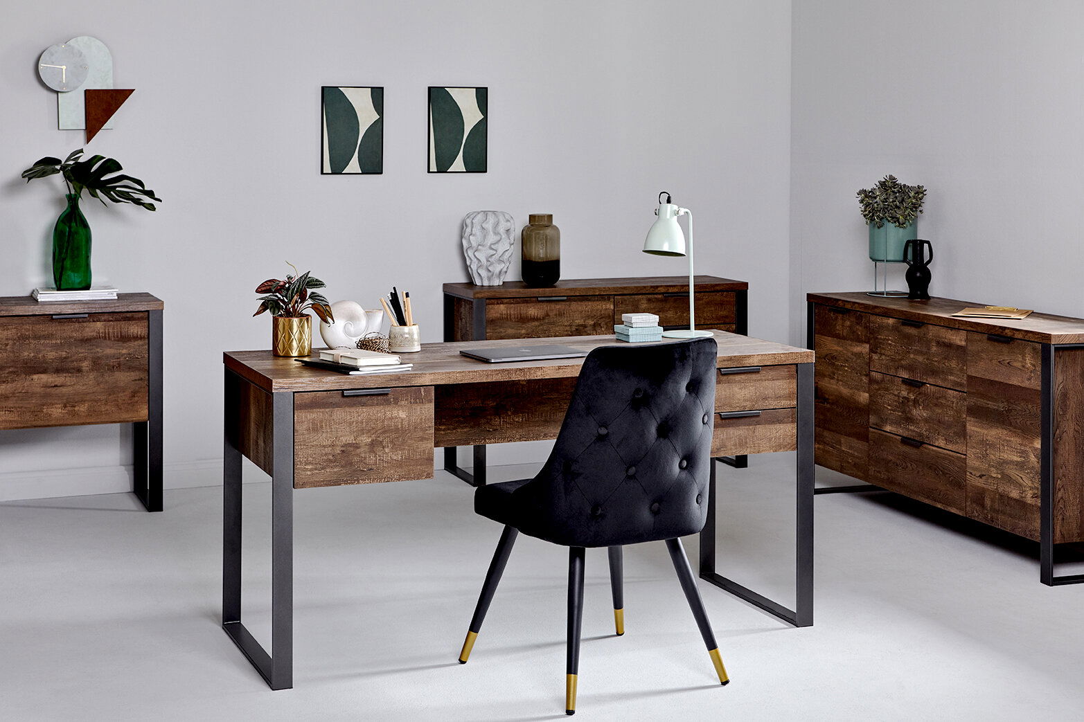 Moderner Schreibtisch aus Holz mit Metallbeinen, umgeben von passenden Möbeln in einem stilvoll eingerichteten Raum, aus der Frontalperspektive.