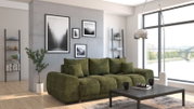 Grünes Funktionssofa in modernem Wohnzimmer mit großen Fenstern und Stadtblick, seitliche Perspektive