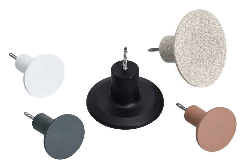 Fünf Wandhaken in verschiedenen Farben und Materialien, aus der Vogelperspektive fotografiert.