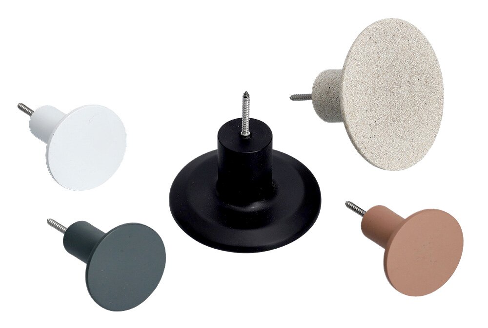 Fünf Wandhaken in verschiedenen Farben und Materialien, aus der Vogelperspektive fotografiert.