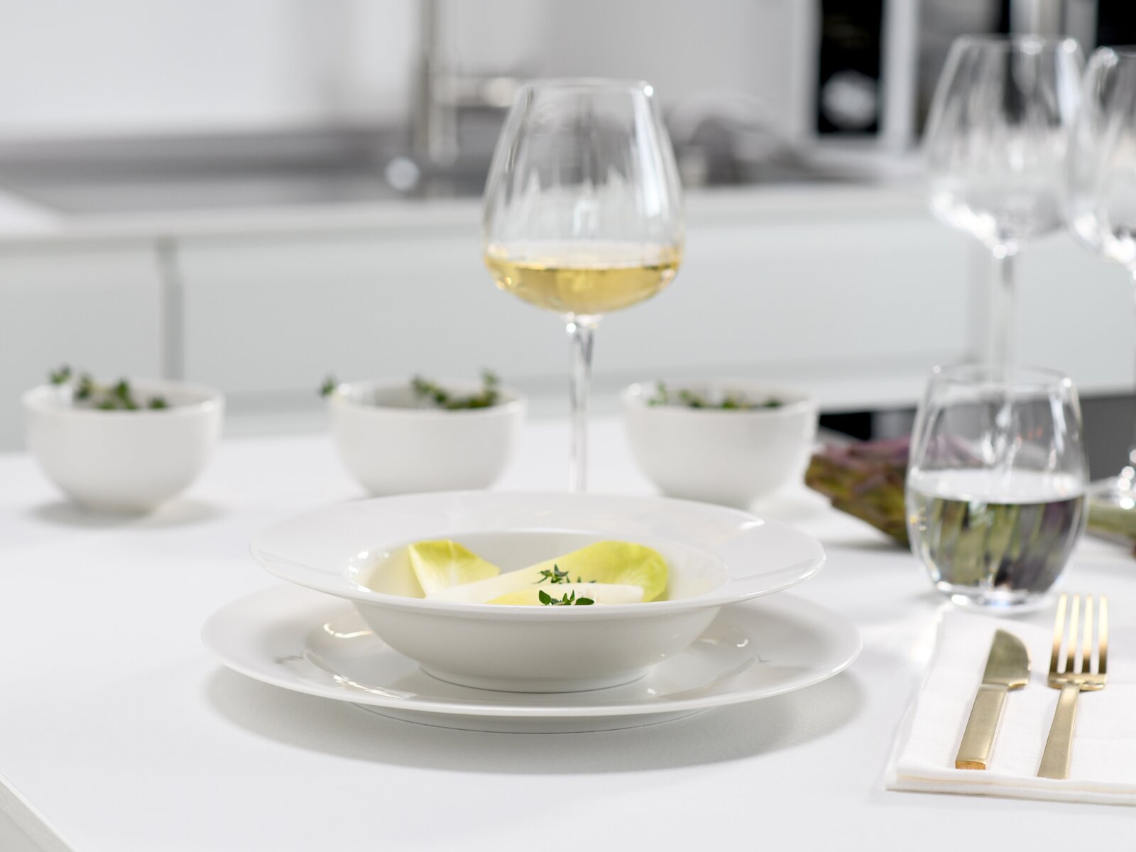 Creatable Tafelservice 12-tlg VENICE Elegantes weißes Porzellan-Suppenteller-Set mit tiefer Schale auf flachem Teller auf gedecktem Tisch, Vorderansicht leicht von oben, im Hintergrund Weinglas und Wasser