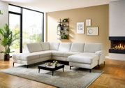 Helles L-förmiges Ecksofa mit beigem Stoffbezug und zwei Chaiselongues in modernem Wohnzimmer, perspektivisch in frontaler 3/4-Ansicht von links aufgenommen