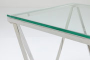 Moderner Beistelltisch mit Glasplatte und verchromtem Metallgestell, seitliche Perspektive.