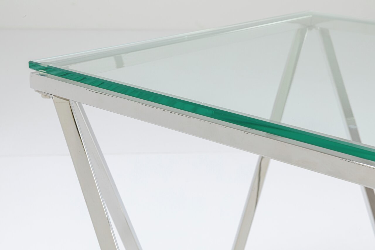 Moderner Beistelltisch mit Glasplatte und verchromtem Metallgestell, seitliche Perspektive.