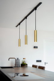 Moderne Pendelleuchte FLORIS in mattgold, dreifach von der Decke hängend über einer Kücheninsel, seitliche Perspektive.