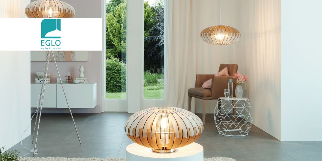 Modernes Wohnzimmer mit stilvollen Leuchten, einem gemütlichen Sessel und einem geometrischen Beistelltisch, mit Blick auf den Garten durch große Fenster.