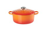 Runder, ofenroter Gourmet-Bräter mit Deckel und zwei Griffen, aus leicht erhöhter Perspektive.
