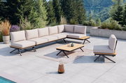 Moderne Loungegarnitur mit hellem Polster und Holzdetails auf einer Terrasse mit Blick auf bewaldete Berge, seitliche Perspektive.