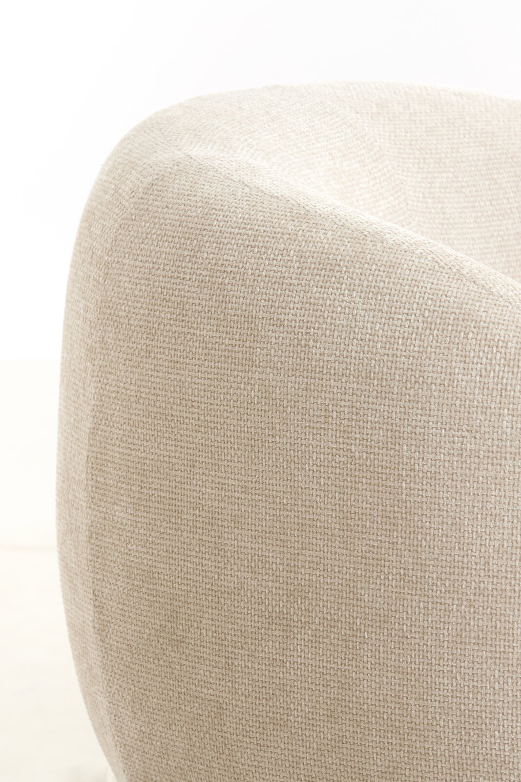Nahaufnahme eines beigen Stuhls mit texturierter Stoffoberfläche, seitliche Perspektive