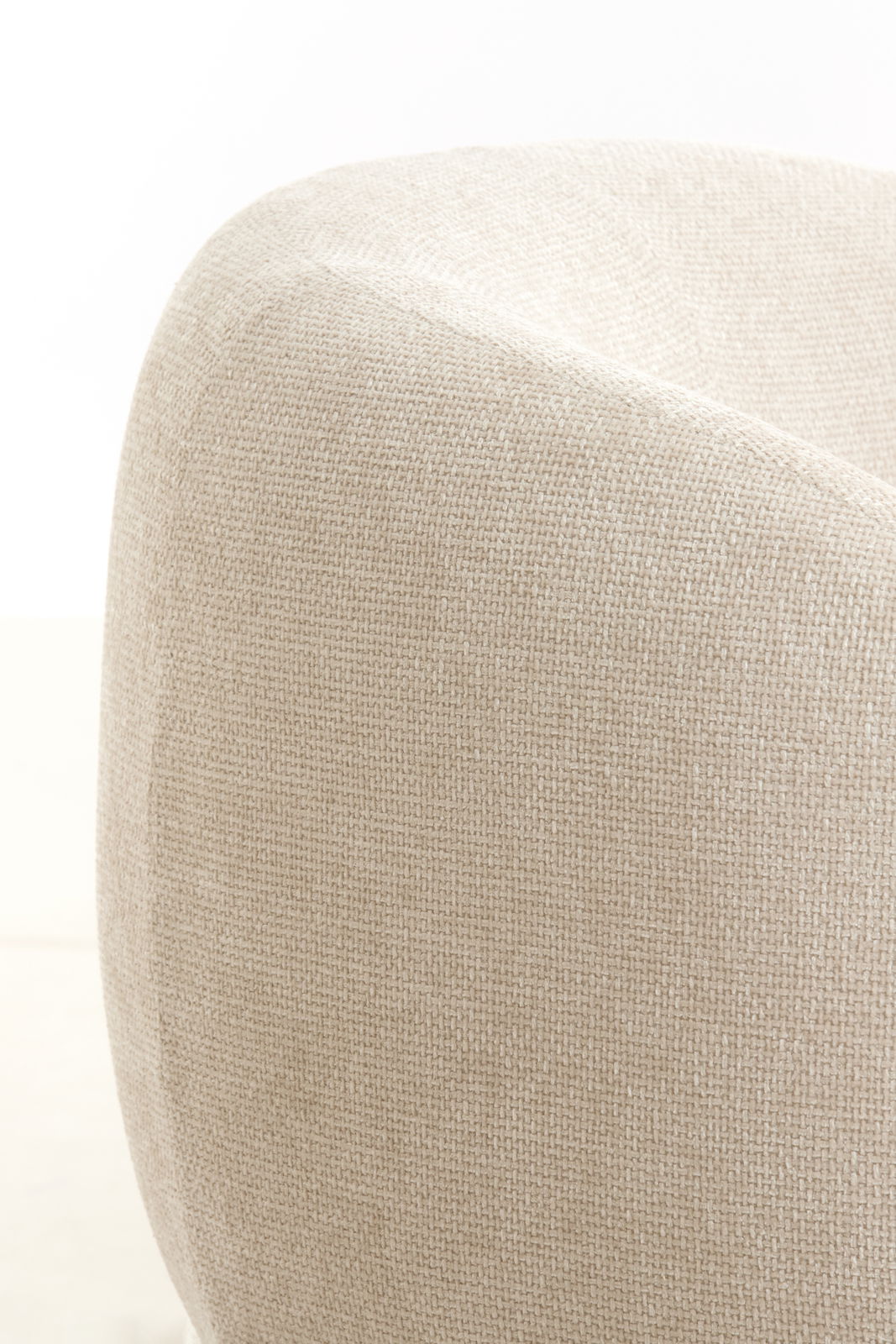Nahaufnahme eines beigen Stuhls mit texturierter Stoffoberfläche, seitliche Perspektive